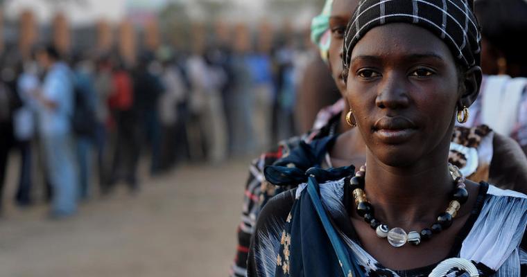 A woman’s face is visible as she stands in a long line of people waiting to vote in Juba, South Sudan.