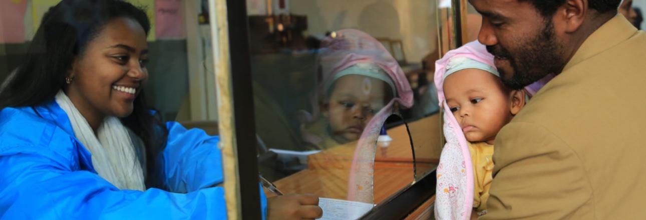 At the launch of a vital registration campaign in Ethiopia in 2016, a father registers the birth of his child. A female registrar records the details on an official form. Photo credit: UNICEF Ethiopia/Sewunet